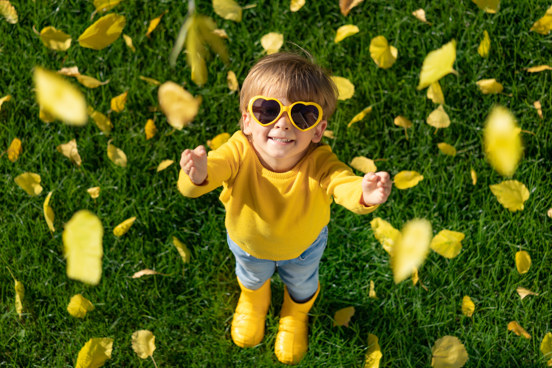 Happy Kid Playing with Autumn Leaves     